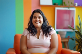 坐在沙发椅上灿烂微笑的微胖美女图片